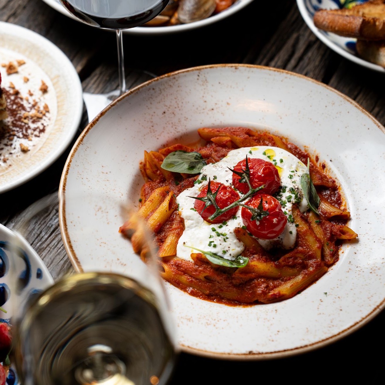 Pasta dish and wine being poured at Zafvino